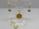 a small display with a gold coin and a pair of earrings on it
