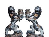 deux figurines représentant deux lions se tenant par la main, posées sur un fond blanc