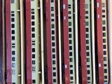 several model trains are in a wooden box on a white surface