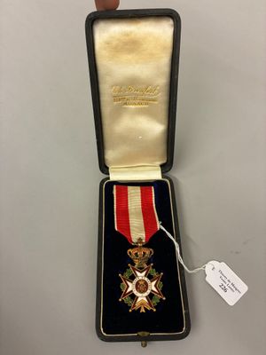 un gros plan d'une personne tenant une médaille dans un écrin
