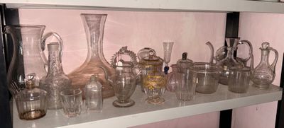 de nombreux vases en verre posés sur une étagère dans une pièce
