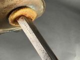 a close up of a metal object with a wooden handle