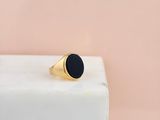 a gold signet ring with a black stone on top