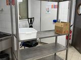 stainless steel shelvings in a commercial kitchen with white tile flooring