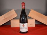 a bottle of wine sitting on a table next to two wooden boxes