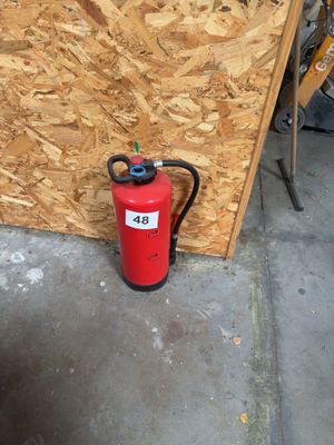 a fire extinguisor sitting next to a wall