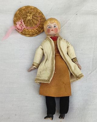 une poupée posée sur le sol à côté d'un panier
