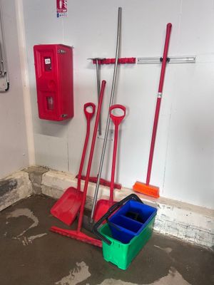 deux pelles rouges et un seau vert dans une pièce