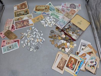 une valise remplie d'argent et de pièces de monnaie posée par terre