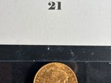 a close up of a gold coin on display in a glass case
