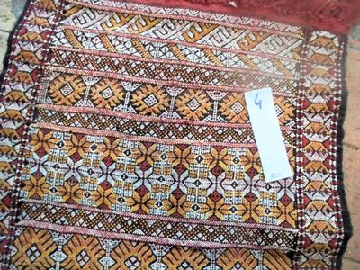 an image of a red and brown rug with a tag on it