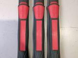 trois outils noirs et rouges posés sur une table blanche