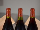 two bottles of wine sitting on a table next to each other