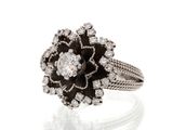 a close up of a diamond and black and white flower ring