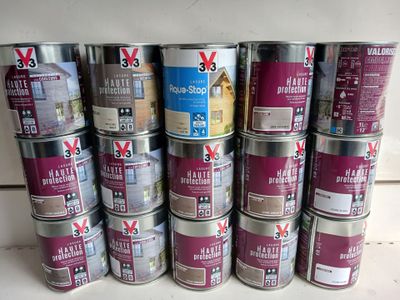 many cans of paint sitting on a counter top