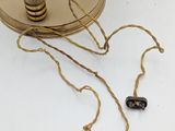 a small wooden object on a table with a rope