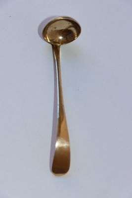 une cuillère en or sur une assiette blanche, avec une cuillère au milieu