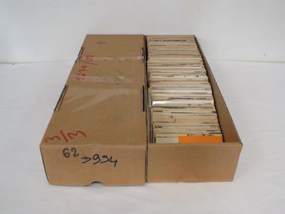 une boîte en carton remplie de CD posée sur une surface blanche