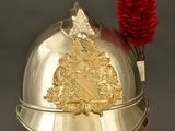 a silver helmet with a red feather on it