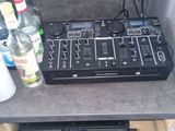 une table sur laquelle se trouvent une table de mixage de DJ et des bouteilles d'alcool