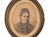 an old picture of a woman in a dress and a hat