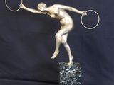 bronze statue of a tennis player holding a racket on a marble base