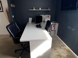 a white desk with a black chair in a room