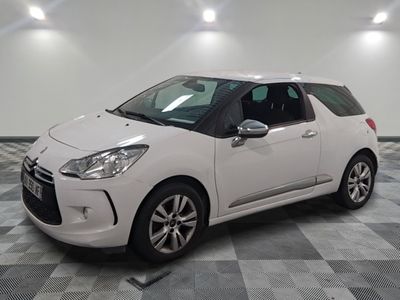 la petite voiture blanche est garée sur un carrelage à carreaux