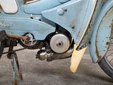 an old blue motorcycle parked on the side of the street