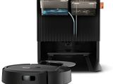 À côté d'un meuble noir se trouve l'image d'un aspirateur robot.