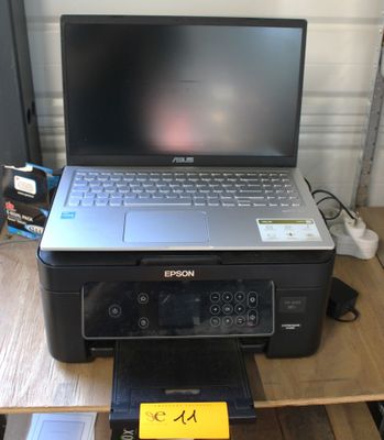 un ordinateur portable et une imprimante posés l'un à côté de l'autre sur un bureau