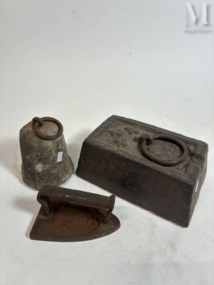 two old iron tools sitting on a white surface