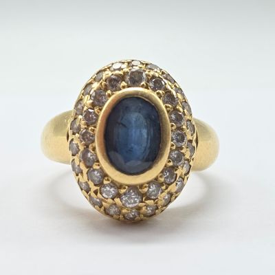 an image of a gold ring with a blue stone surrounded by white diamonds
