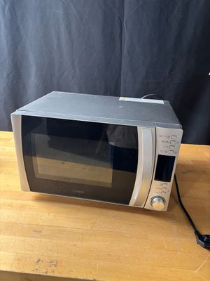 a microwave that is sitting on a wooden table