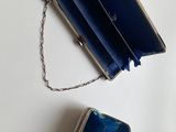 a small blue purse with a chain hanging from it