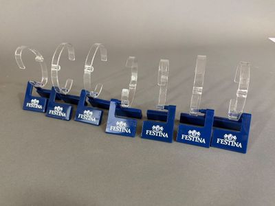 quatre trophées en acrylique transparent sont posés sur une surface grise