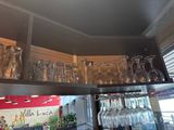 many glasses on the shelf above the wine glasses