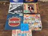 beaucoup de livres posés sur une table, à côté d'un sac de pop-corn