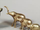 three gold elephants standing next to each other on a table