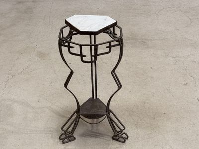 a metal stand with a marble top on top of it