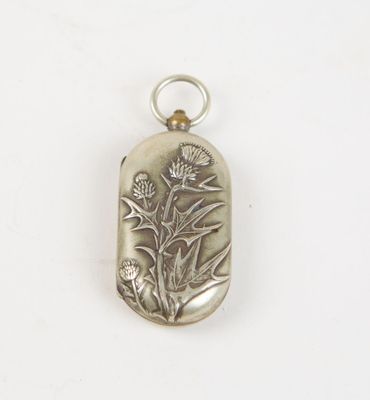 a close up of a silver pendant with a flower on it