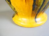 un vase jaune orné d'un motif noir et jaune