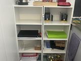 a kitchen with a black tile floor and a white bookcase