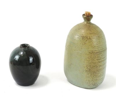two vases sitting next to each other on a white surface