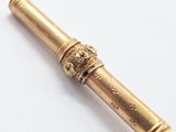 an antique brass telescope with a gold handle on a white surface