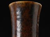 a close up of a brown vase on a black background
