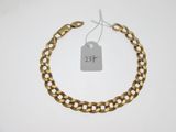 gros plan d'un bracelet en chaîne en or avec une étiquette de prix