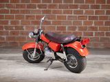 a red motorcycle that is parked in front of a brick wall