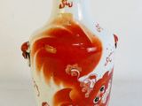 un vase blanc orné d'un motif rouge et blanc