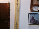 a tall thermometer hanging on the wall in a room